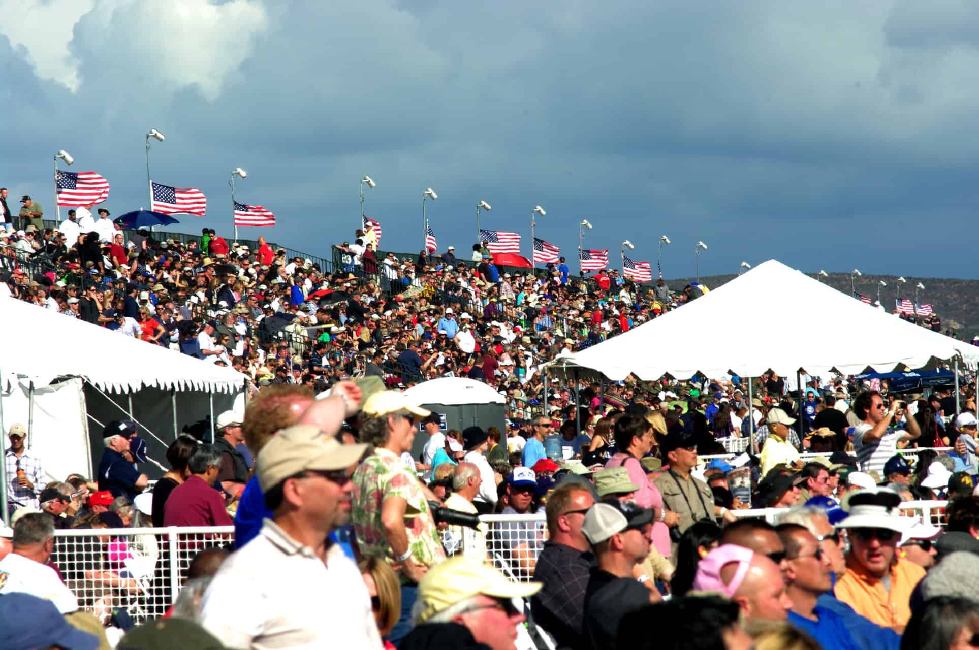 Crowd of people in the stands watching the air show.